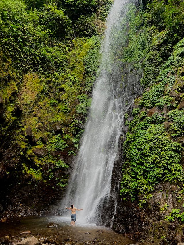 Man Stands under Waterfall in monteverde